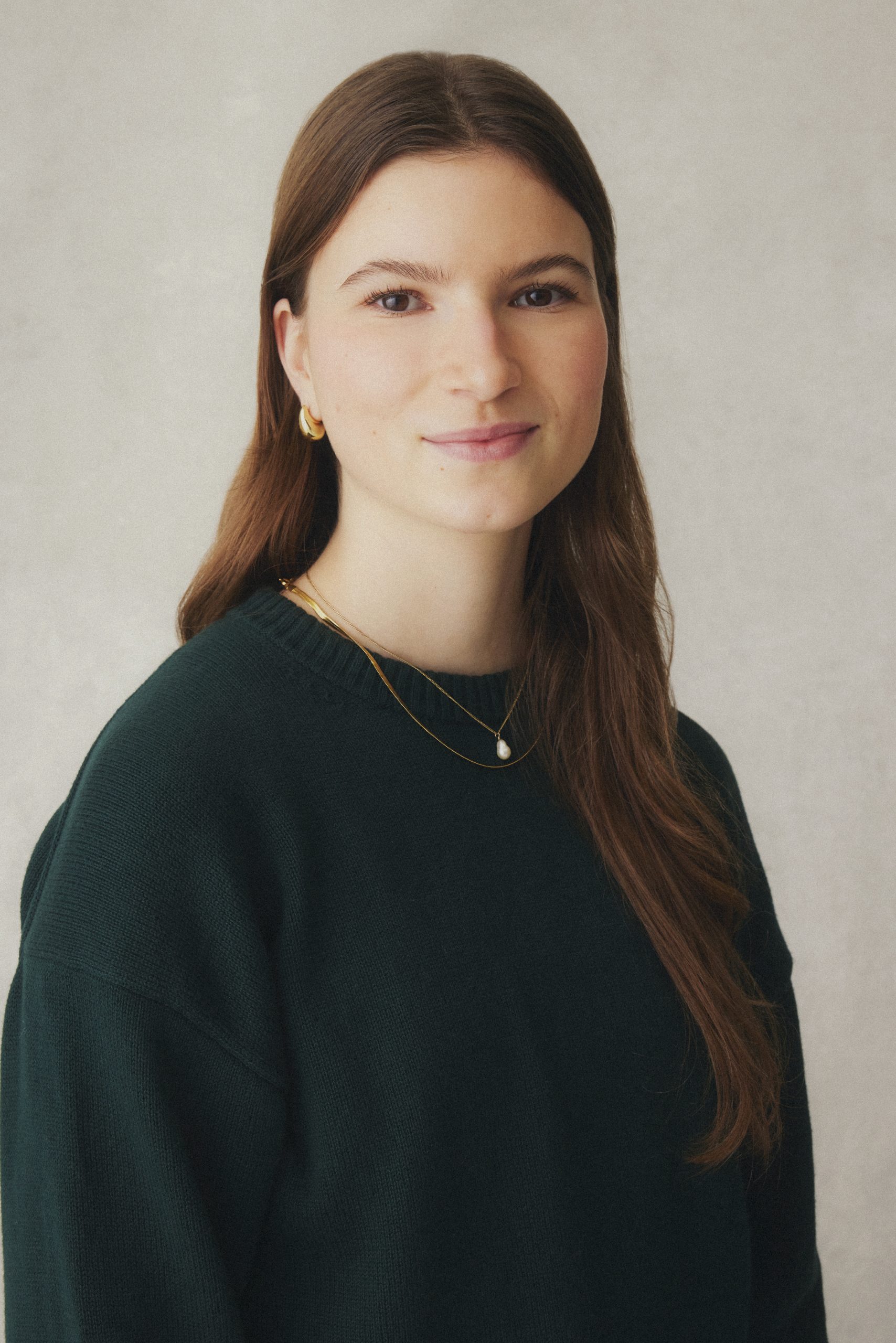 Portrait of a long haired youth wearing a green sweater